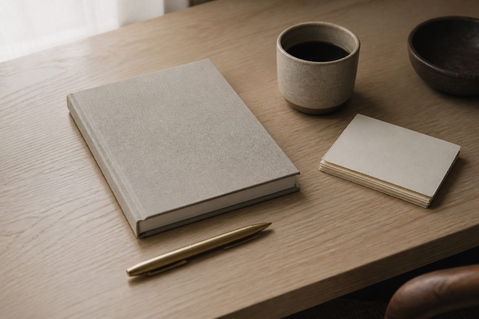 Un escritorio tranquilo con un cuaderno, un bolígrafo y una taza de café